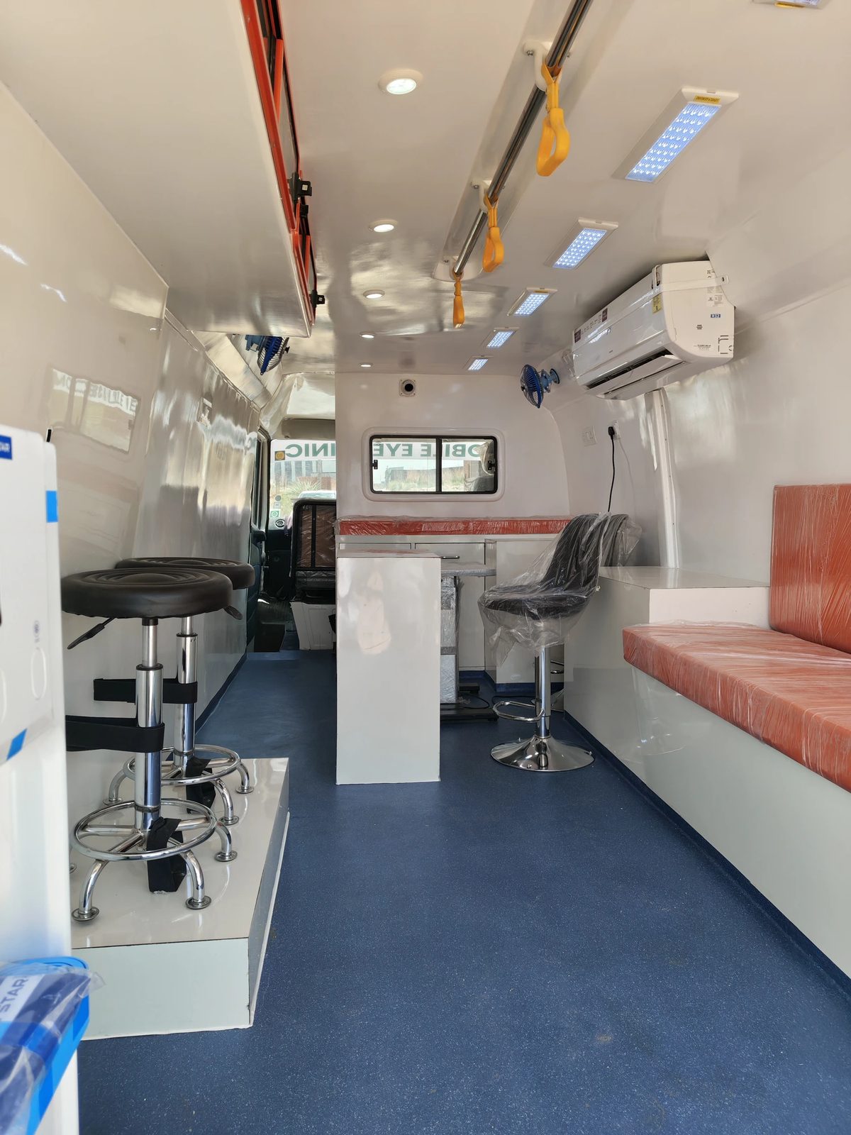 Mobile eye clinic interior showing examination seating and cabinetry